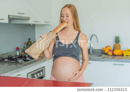 Pregnant woman eating bread in the kitchen. Exploring the impact of gluten during pregnancy: understanding the potential benefits and risks for maternal health and fetal development Pregnant woman eating bread in the kitchen. Exploring the impact of gluten during pregnancy: understanding the potential benefits and risks for maternal health and fetal development 112356313