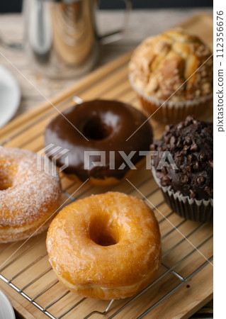 glazed donuts with coffee and muffins 112356676