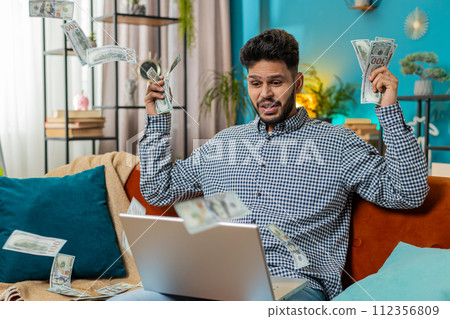 Money cash dollar rain falling on man celebrating success, winning good news, lottery jackpot luck Money cash dollar rain falling on man celebrating success, winning good news, lottery jackpot luck 112356809