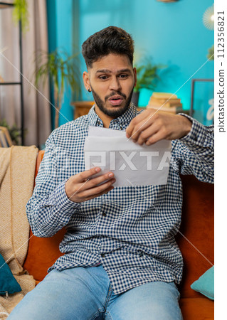 Man open envelope letter reads it feel happy, career growth advance promotion, bank loan approve Man open envelope letter reads it feel happy, career growth advance promotion, bank loan approve 112356821