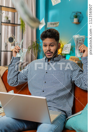 Money cash dollar rain falling on man celebrating success, winning good news, lottery jackpot luck 112356907