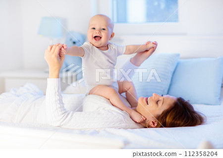 Mother and baby on a white bed 112358204