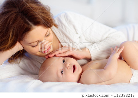 Mother and baby on a white bed 112358212