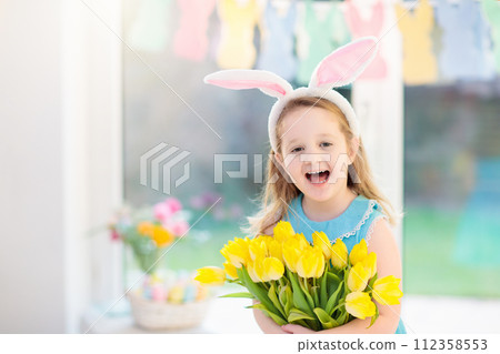 Little girl in bunny ears on Easter egg hunt 112358553