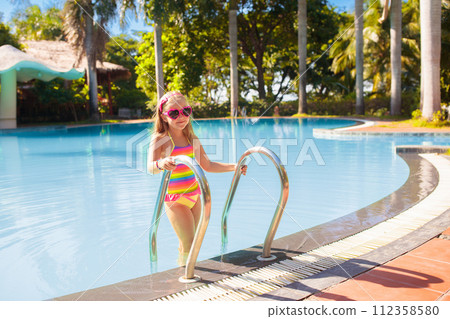 Child in swimming pool with ball. Kids swim. Child in swimming pool with ball. Kids swim. 112358580