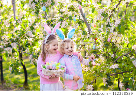 Easter egg hunt. Kids with bunny ears and basket. Easter egg hunt. Kids with bunny ears and basket. 112358589