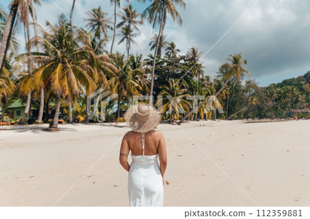 woman walking on beach and enjoying sun at tropical resort 112359881
