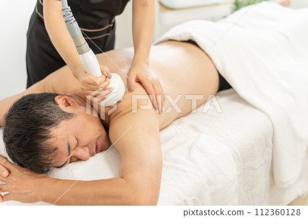 An esthetician and a man who perform slimming esthetics using a cavitation esthetics machine at a men's esthetics salon (arms and shoulders) An esthetician and a man who perform slimming esthetics using a cavitation esthetics machine at a men's esthetics salon (arms and shoulders) 112360128