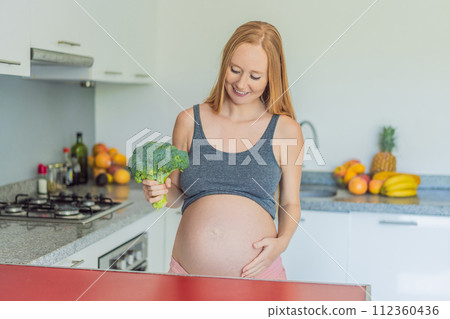 Embracing a nutrient-rich choice, a pregnant woman eagerly prepares to enjoy a wholesome serving of broccoli, prioritizing healthy and nourishing options during her pregnancy Embracing a nutrient-rich choice, a pregnant woman eagerly prepares to enjoy a wholesome serving of broccoli, prioritizing healthy and nourishing options during her pregnancy 112360436