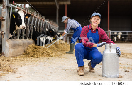 Farmer woman is holding can at cow farm Farmer woman is holding can at cow farm 112360823