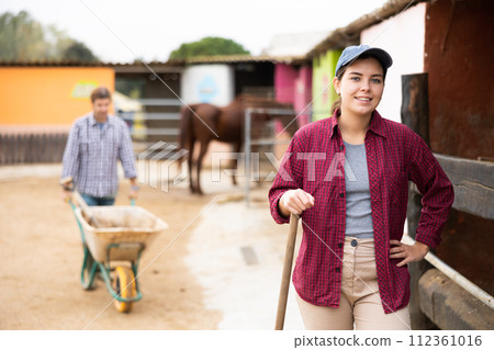 Young farm worker standing with a smile and instruments Young farm worker standing with a smile and instruments 112361016