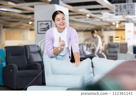 Young woman is looking for new furniture 112361141