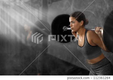 Slender girl trains muscles of arms and back using barbell and differentiated weighting in gym Slender girl trains muscles of arms and back using barbell and differentiated weighting in gym 112361264
