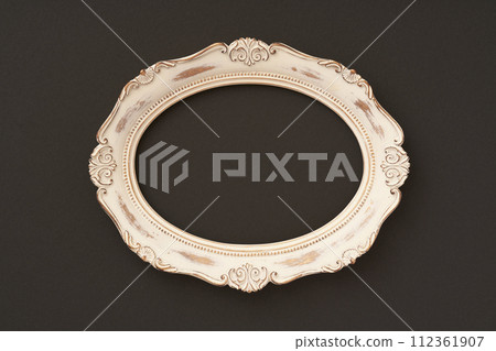 Antique oval picture frame hung on black background Antique oval picture frame hung on black background 112361907