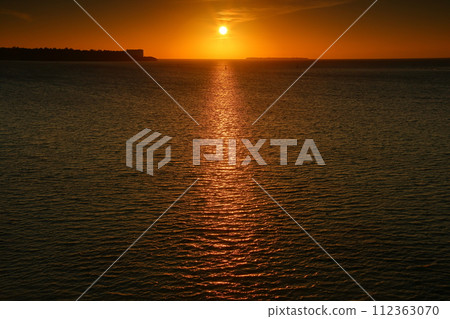 沖繩縣國頭郡本部町外口，濱本大橋的夕陽和光路，瀨底島和水納島的剪影 112363070