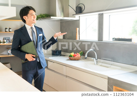 A male planner/advisor/coordinator for a house builder who recommends system kitchens. A male planner/advisor/coordinator for a house builder who recommends system kitchens. 112363104