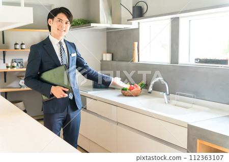 A male planner/advisor/coordinator for a house builder who recommends system kitchens. A male planner/advisor/coordinator for a house builder who recommends system kitchens. 112363107