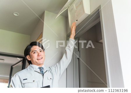 A man wearing the work clothes of an electric power company investigator who came to conduct an electrical safety investigation. A man wearing the work clothes of an electric power company investigator who came to conduct an electrical safety investigation. 112363196