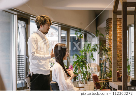 A woman getting her hair cut at a beauty salon A woman getting her hair cut at a beauty salon 112363272