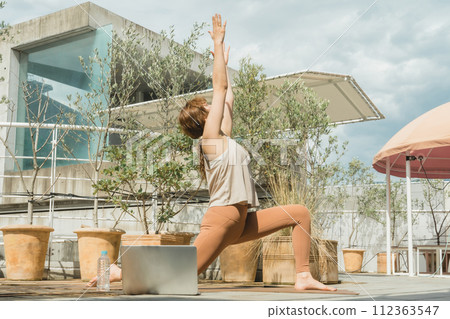 A female yoga instructor who does sun salutation, online yoga, and remote yoga. A female yoga instructor who does sun salutation, online yoga, and remote yoga. 112363547