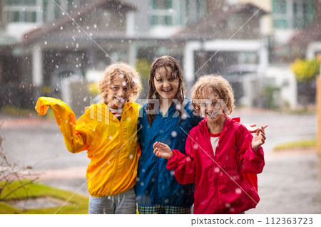 Kids play in rain. Children walk in rainy weather 112363723