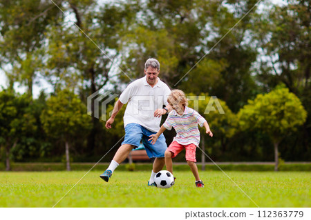 Father and son play football. Dad and kid run. 112363779