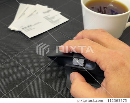 商業場景：手拿著滑鼠、咖啡和名片 112365575