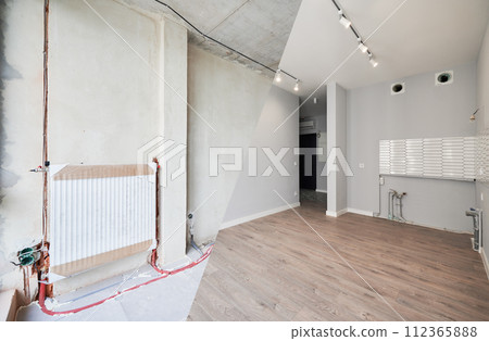 Empty room with installed heating system before and after restoration. Comparison of old apartment and new renovated flat with parquet floor, radiator and white wall. Home renovation concept. Empty room with installed heating system before and after restoration. Comparison of old apartment and new renovated flat with parquet floor, radiator and white wall. Home renovation concept. 112365888