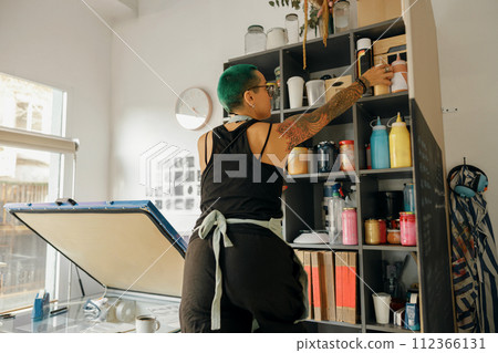 Female worker takes of bank with ink on background of own design studio  112366131