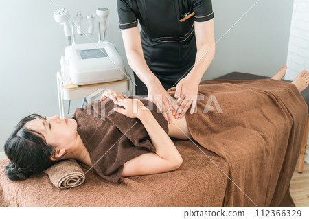 A woman receiving treatment at a beauty salon that provides hand massage and hand beauty treatment (cellulite/lymph drainage) 112366329