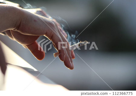 While men are smoking and having a conversation 112366775