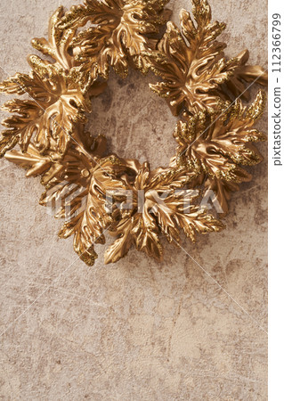 Golden Christmas wreath hung on marble background 112366799