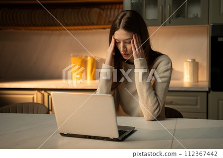 Young Woman Overwhelmed by Emotion While Working on Laptop at Home Young Woman Overwhelmed by Emotion While Working on Laptop at Home 112367442