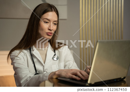 Exhausted Female Healthcare Professional Taking a Break During a Long Shift Exhausted Female Healthcare Professional Taking a Break During a Long Shift 112367450