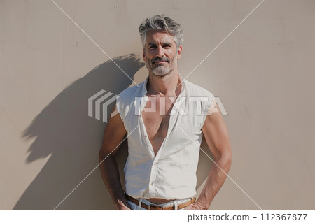 A man with a beard and mustache stands in front of a wall 112367877