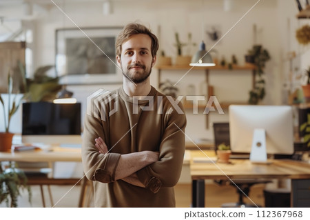 A man is standing in front of a desk with a computer monitor and a potted plant A man is standing in front of a desk with a computer monitor and a potted plant 112367968