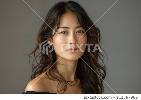 A woman with long hair and a necklace is smiling 112367969