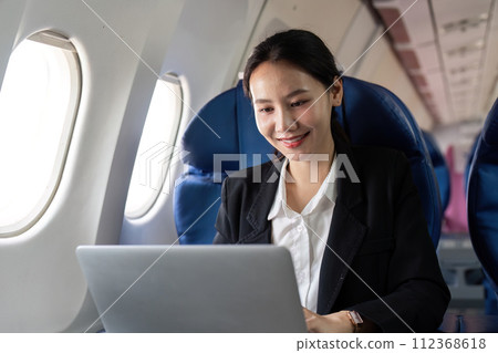 Asian young woman using laptop at first class on airplane during flight, Traveling and Business concept Asian young woman using laptop at first class on airplane during flight, Traveling and Business concept 112368618