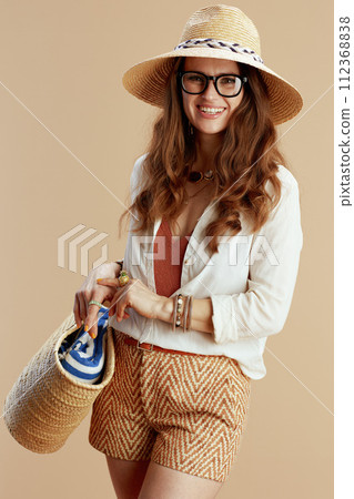 happy elegant woman in blouse and shorts on beige 112368838
