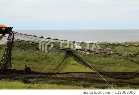 狹長的野付半島沿岸存放著色彩繽紛的漁具。 狹長的野付半島沿岸存放著色彩繽紛的漁具。 112369306