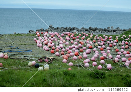 Colorful fishing gear is stored along the coast of the long and narrow Notsuke Peninsula. Colorful fishing gear is stored along the coast of the long and narrow Notsuke Peninsula. 112369322