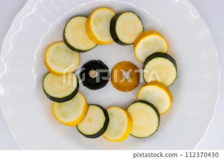 Raw zucchini sliced into rounds, green and yellow zucchini Raw zucchini sliced into rounds, green and yellow zucchini 112370430