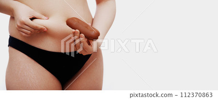 Overweight female body. Beautiful woman holding Overweight female body. Beautiful woman holding 112370863