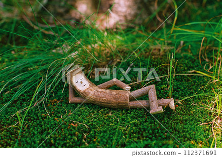 A small tree fairy taking a comfortable nap on the green moss. A small tree fairy taking a comfortable nap on the green moss. 112371691