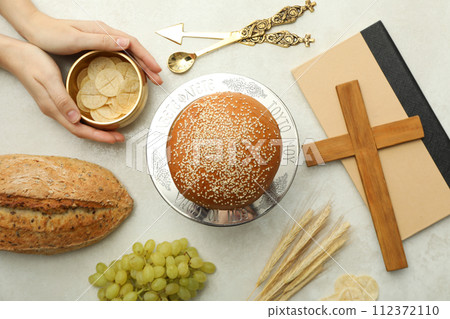 Bread, hands, grapes, wooden cross on book and spikelets on light background, top view Bread, hands, grapes, wooden cross on book and spikelets on light background, top view 112372110