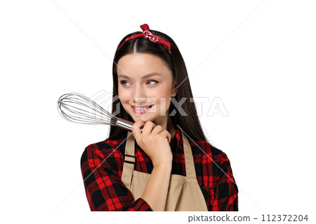 Housewife girl with kitchen utensils in her hands, on a gray background. 112372204