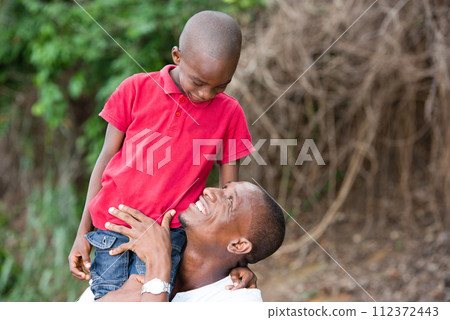 Happy father and child spending time outdoors and laughing 112372443