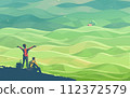a young couple resting on the top of a hill, admiring the beautiful scenery of numerous hills of agricultural farmland 112372579