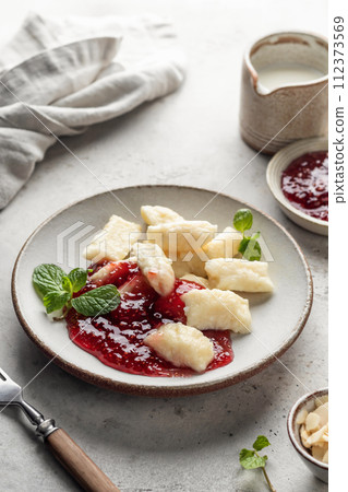 Lazy dumplings, vareniki with raspberry jam decorated with almond petals and mint leaves. Boiled cottage cheese homemade gnocchi Lazy dumplings, vareniki with raspberry jam decorated with almond petals and mint leaves. Boiled cottage cheese homemade gnocchi 112373569
