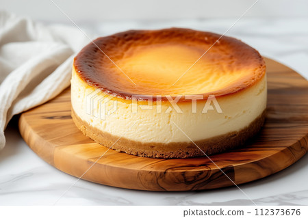 Fluffy baked cheesecake on a wooden plate 112373676